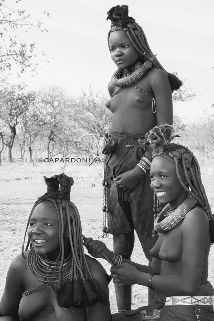Himba women at the village who smile and explain their culture, Kamanjab, Namibia