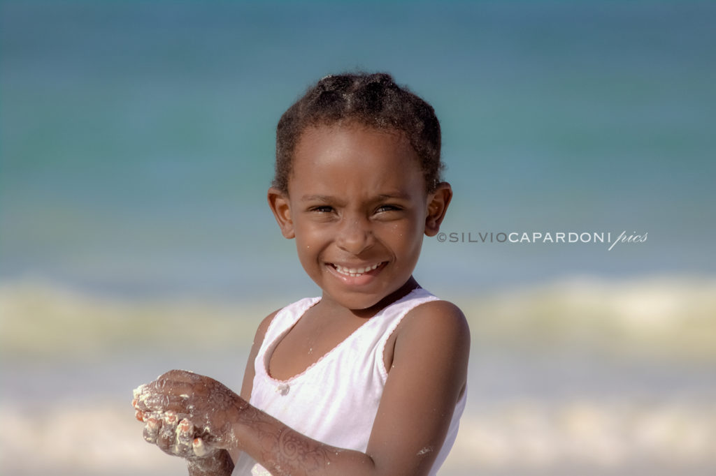 She the sand and the sea is a portrait of a child playing on the beach, Zanzibar, Tanzania