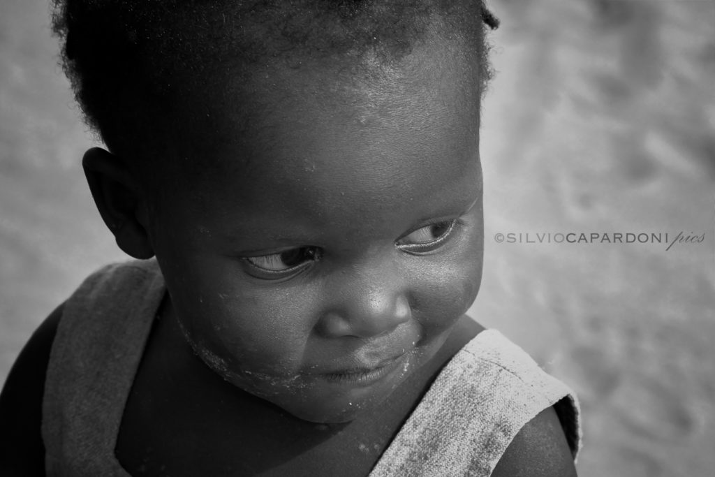 Puzzled look of an African child in black and white close-up portrait, Tsavo, Kenya