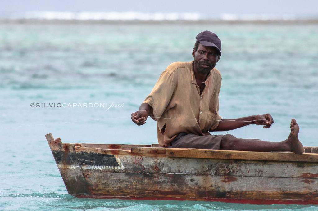 Fisherman on his boat with fishing line in his hands waiting for the bite of the fish, Zanzibar, Tanzania