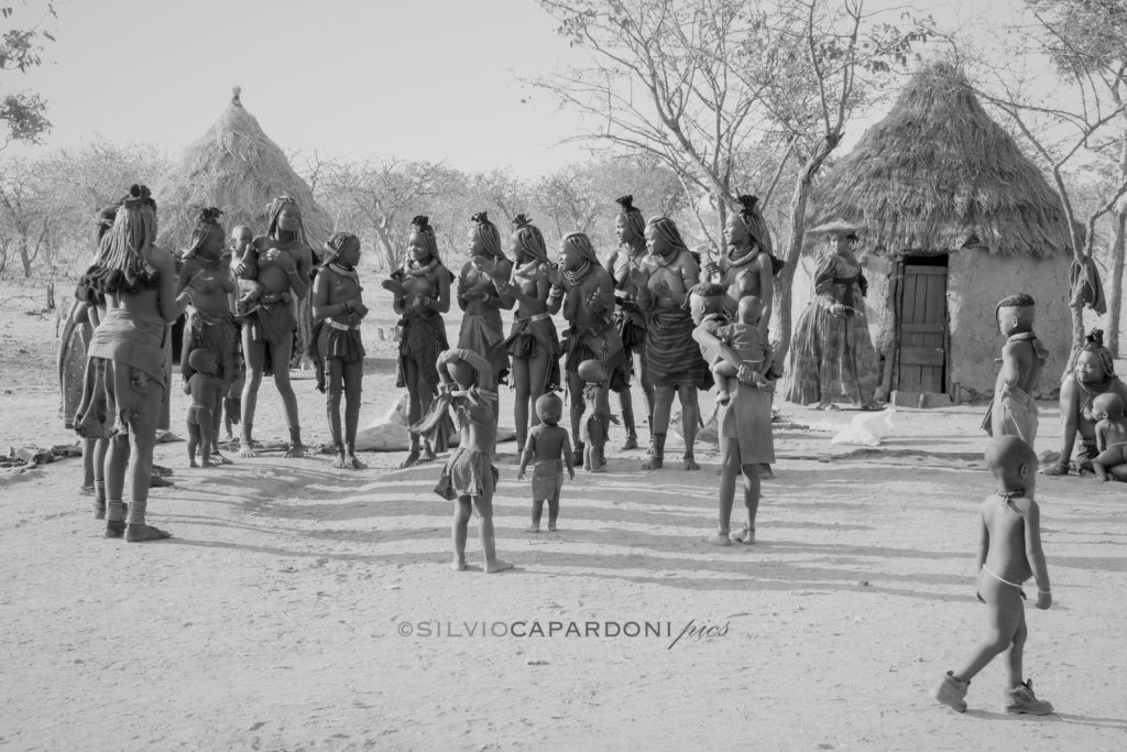 Daily scenes in a Himba village with gathered women and children, Opuwo, Namibia